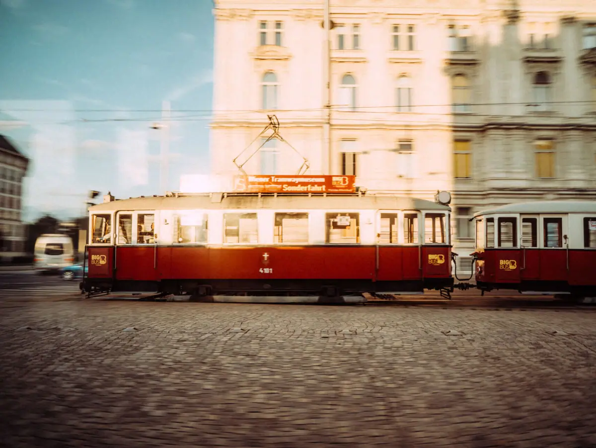Vienna Tram A red and a white tram on a street.