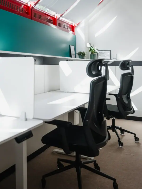 Impuls Raum Garmisch-Partenkirchen A room with white desks and chairs.