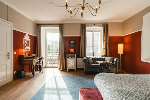 HENRI Kitzbühel hotel room A room with a sofa and a desk.