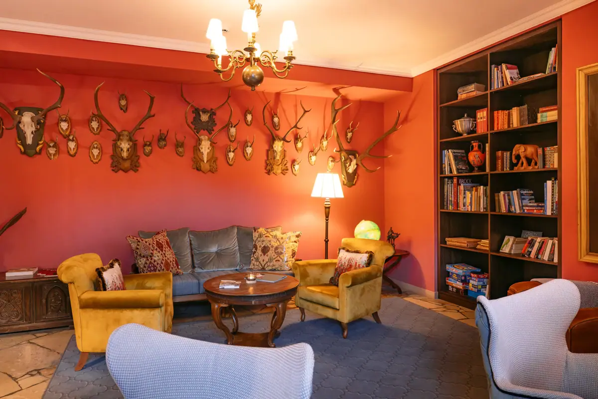 A room with a sofa and chairs.