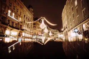 A street with illuminated buildings at night.