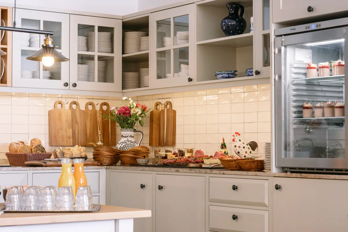 A kitchen with white cupboards and white worktops.