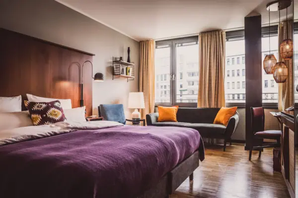 HENRI Düsseldorf Bedroom with a purple bed and sofa