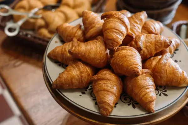 A plate of croissants on a table.