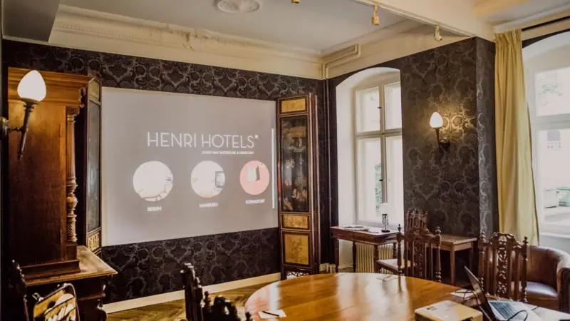 A room with a projection screen and wooden furniture.