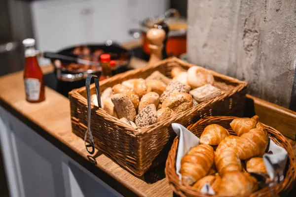 Bread baskets on the breakfast buffet at the HENRI Hotel Hamburg Baskets of bread and croissants on a counter