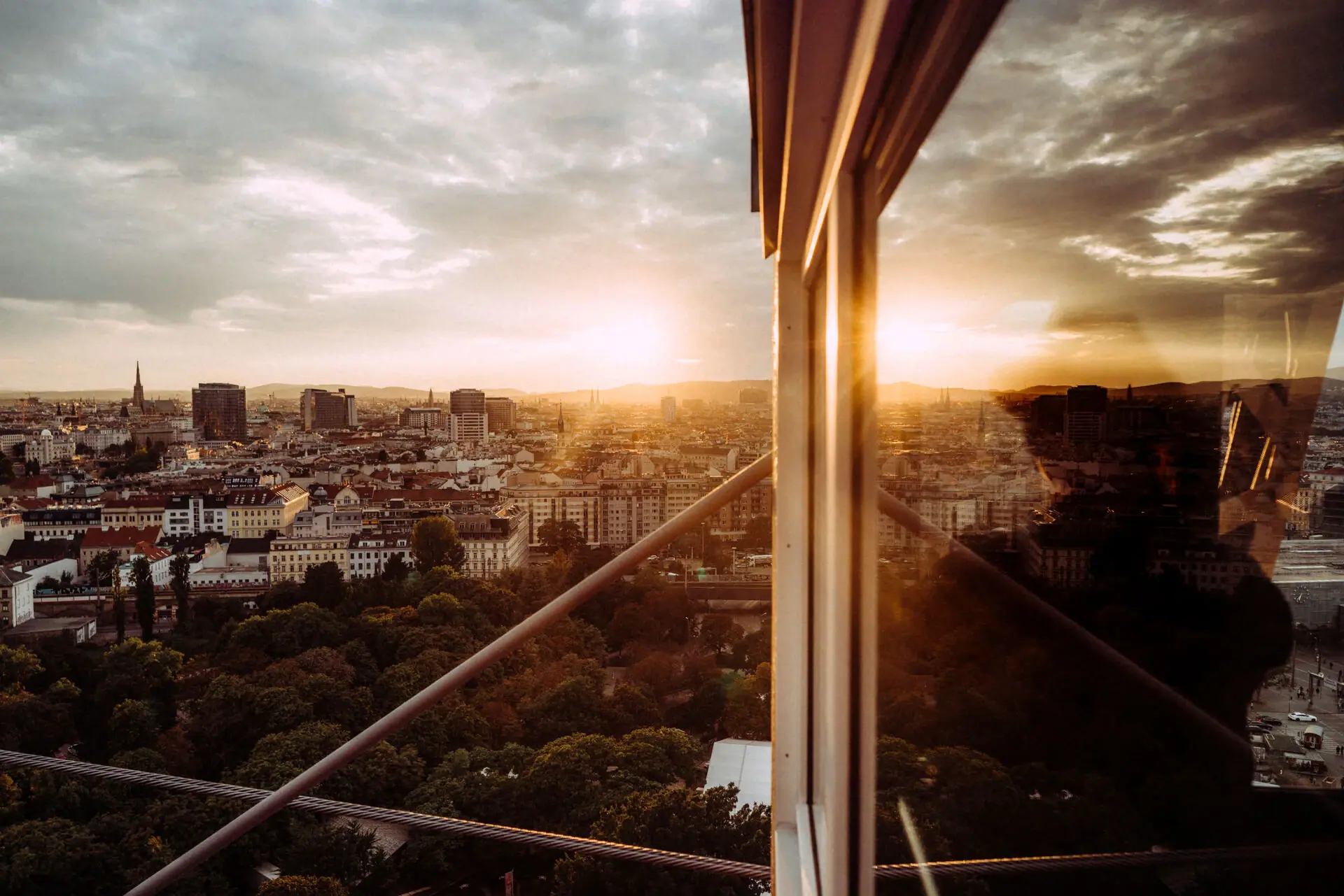 View of a city through a window with clouds and sky in the background.