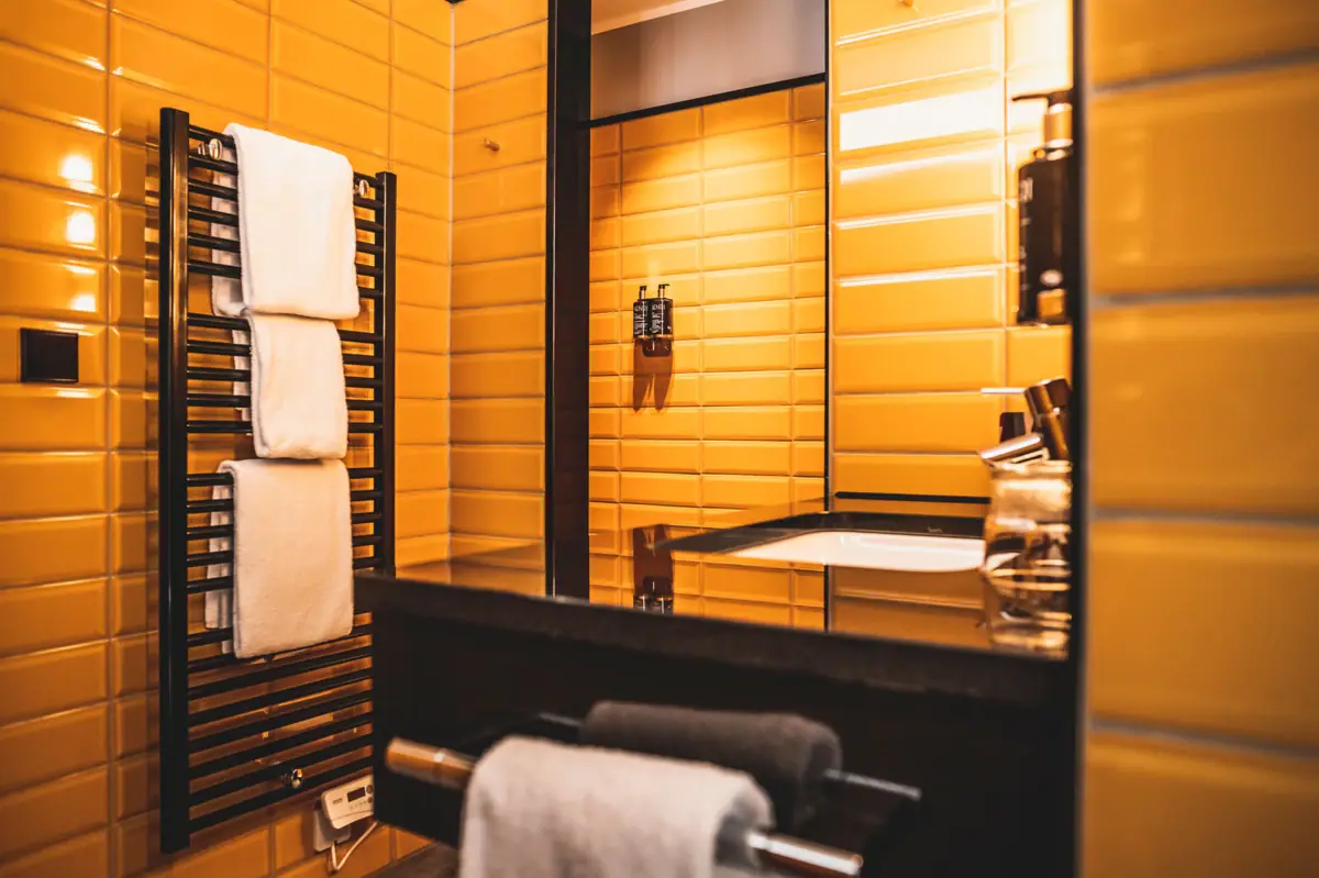 Bathroom with yellow tiled walls and a mirror