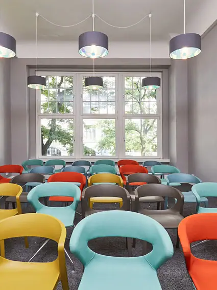 A room with lots of colourful chairs.