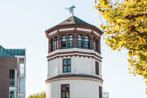 A man is cycling past a round building.