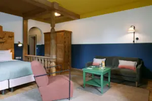 A room with two beds and a green table.