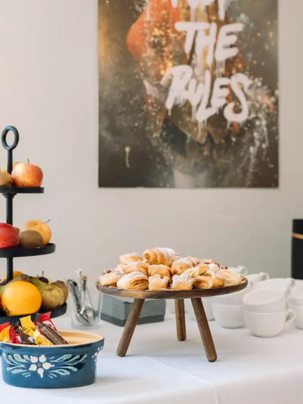 A table with snacks, fruit and pastries.