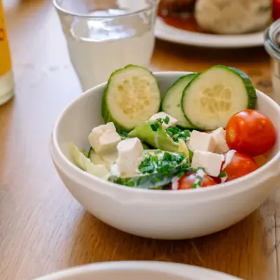 A bowl of salad with cucumber and tomatoes.