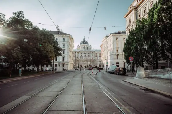 Train tracks in a city with buildings and trees nearby.