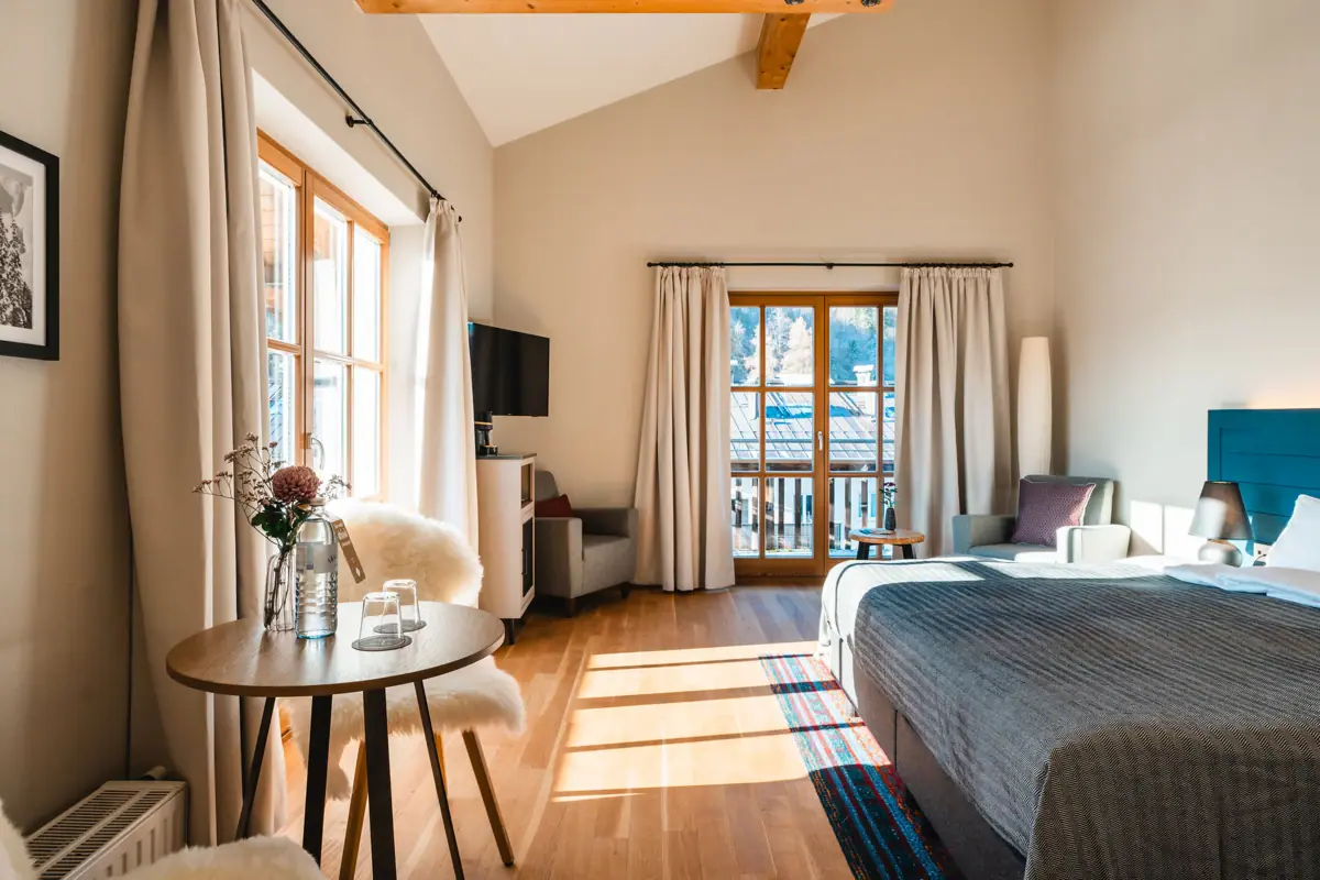 A room with a bed, a table and chairs.