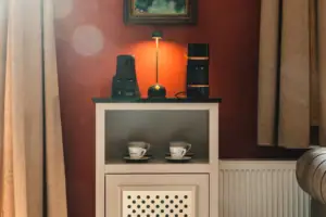 A room bar at the HENRI Kitzbühel with cups and a lamp on top.