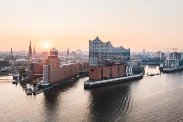 City view of Hamburg with water surface and buildings at sunset.