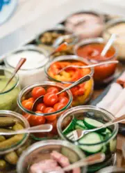 Breakfast buffet with a variety of fresh ingredients displayed in glass jars.