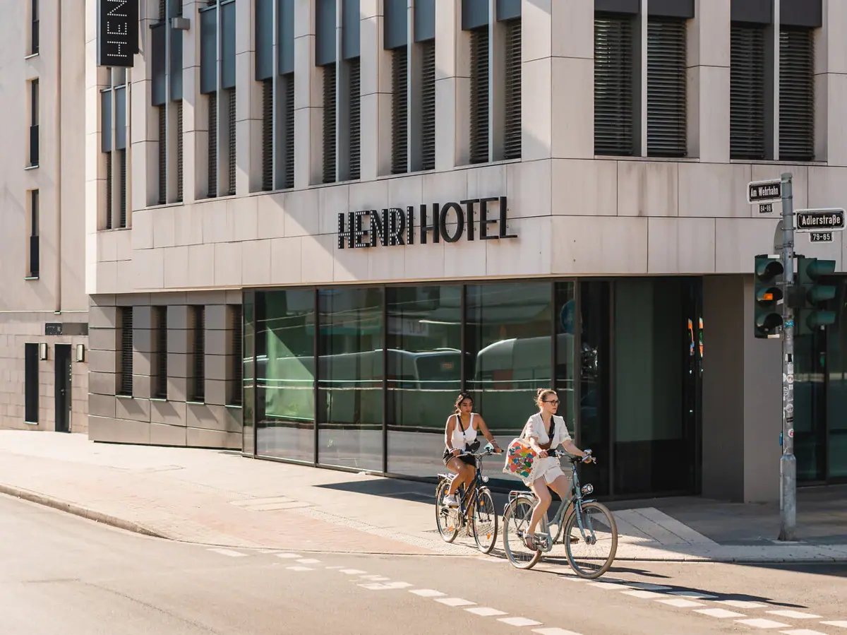 A group of people are cycling past a hotel.