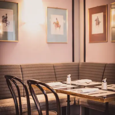 A table with a set of napkins and chairs in a restaurant.