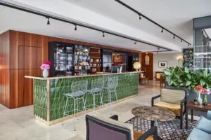 A bar with green tiles and chairs.