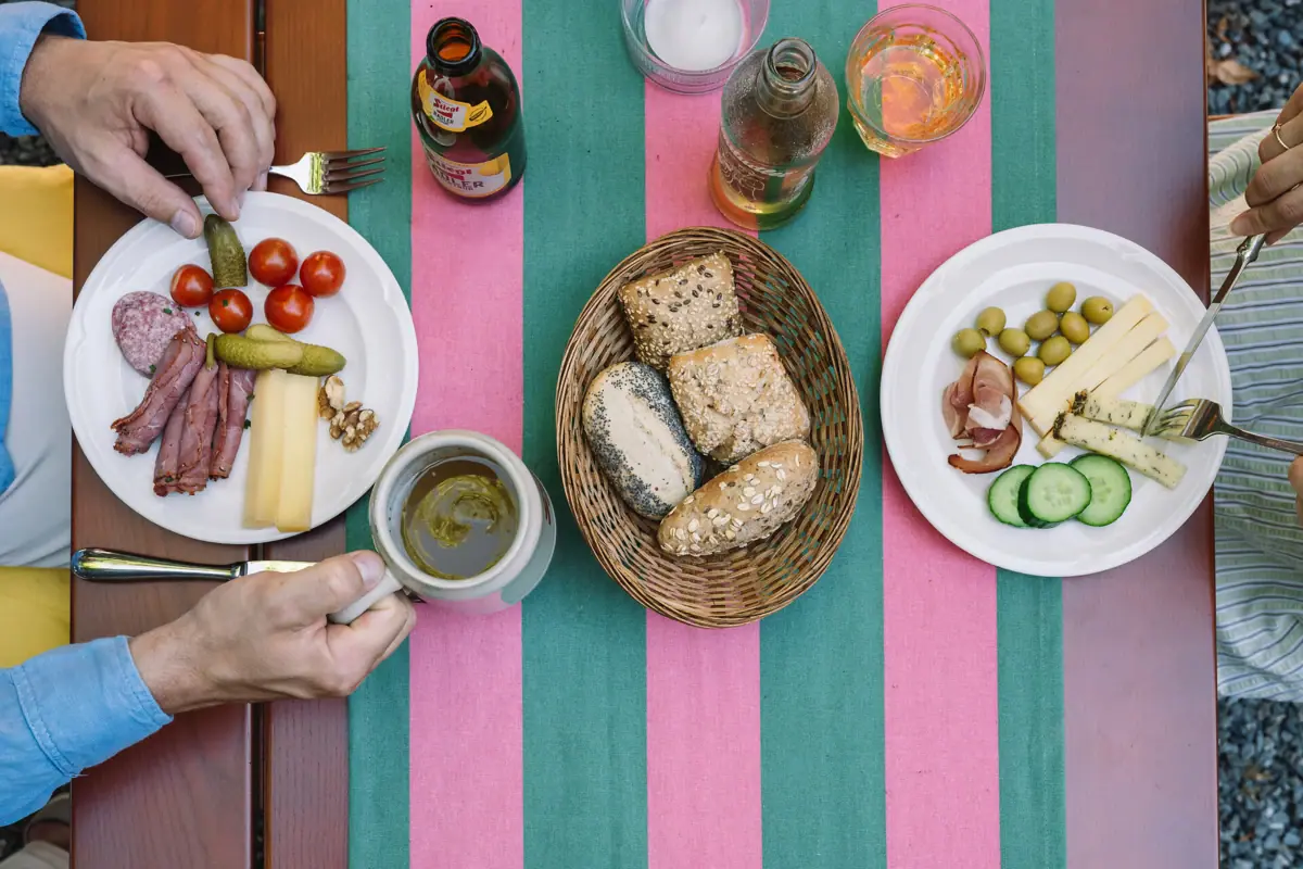 Person holding a cup and a plate of food.