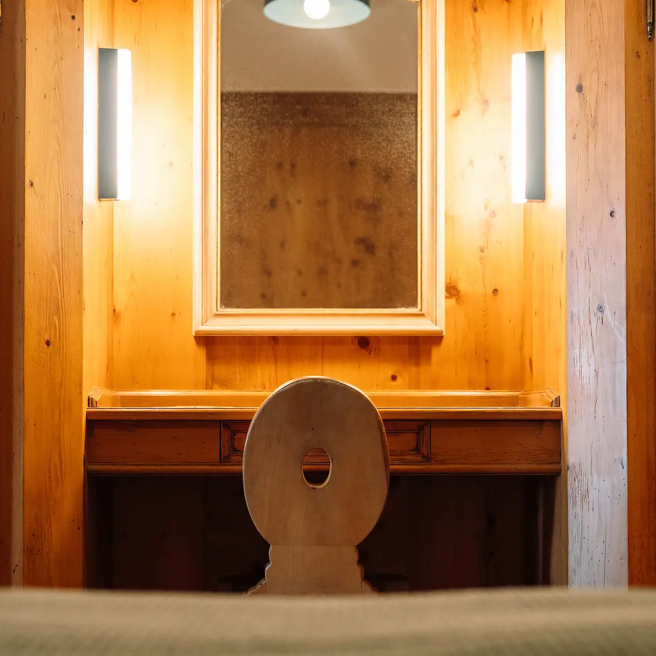 A mirror above a chair in a room