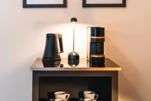 Kettle, coffee machine and cups on a shelf