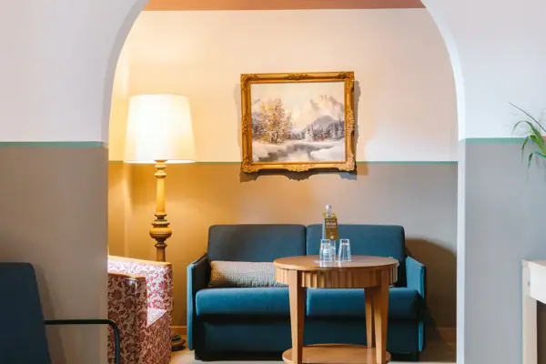 A hotel room at the HENRI Hotel in Garmisch-Partenkirchen, featuring a sofa and a table.
