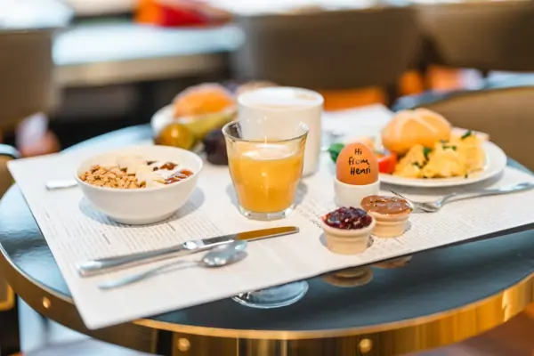 A laid breakfast table Breakfast on a table set with crockery and cutlery.