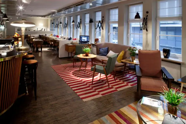 Lounge and dining area at HENRI Hamburg A room with a sofa and chairs.