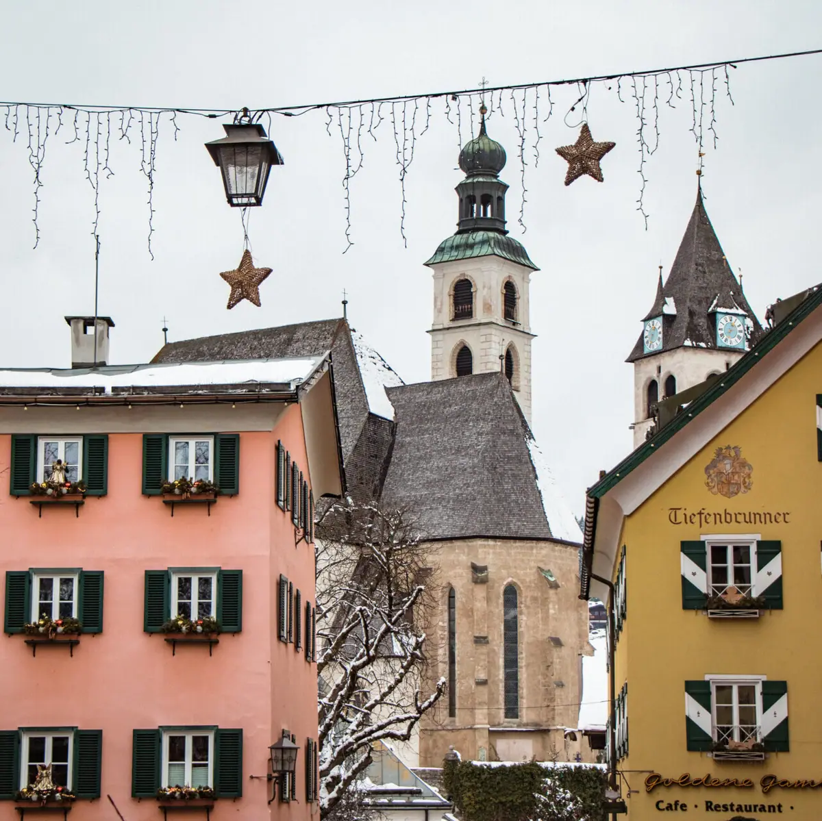 A group of illuminated buildings with fairy lights in the sky.