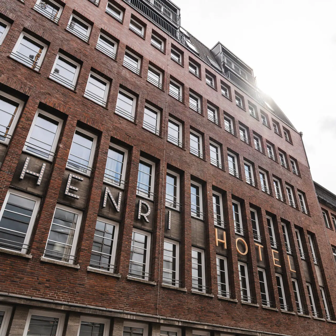 A building with a high tower in front of a cloudy sky.