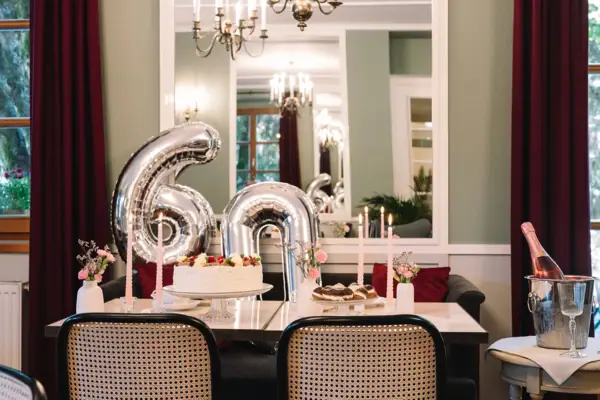 A table with a cake and balloons.