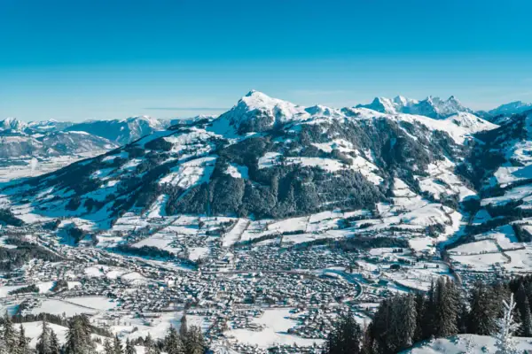 Snow-covered mountain with a town on it.
