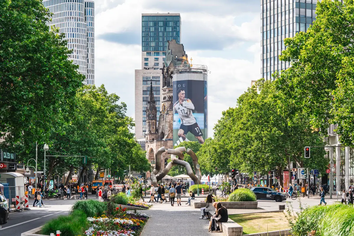 A group of people walking on a pavement in a city.