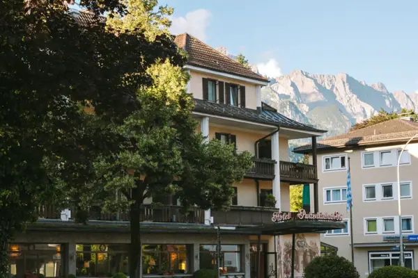A building with trees and mountains in the background.