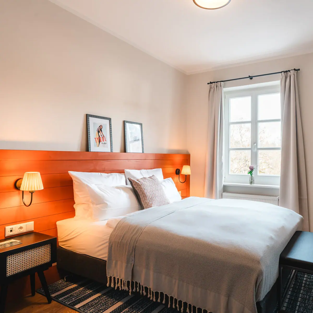 A bed with a wooden headboard and a lamp.
