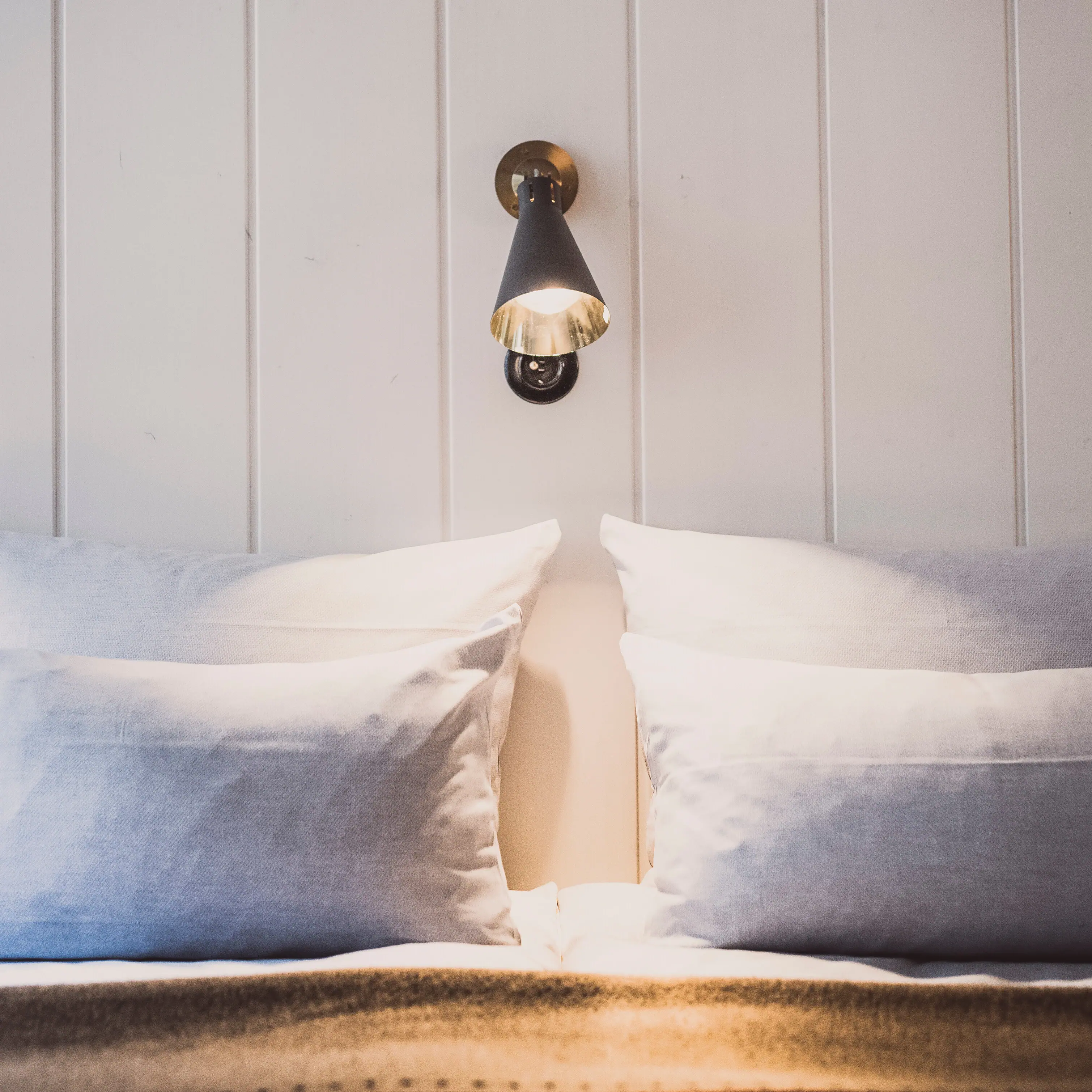 Wall lamp above a bed with cushion