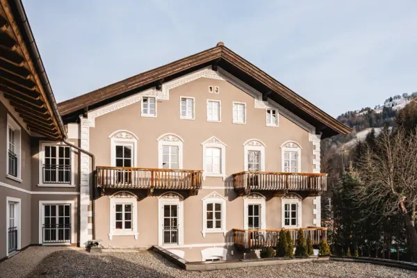 HENRI Kitzbühel exterior view A building with many windows and a driveway.