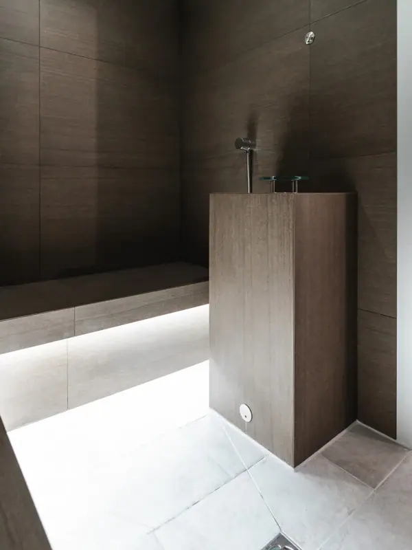 A bathroom with washbasin and bench.