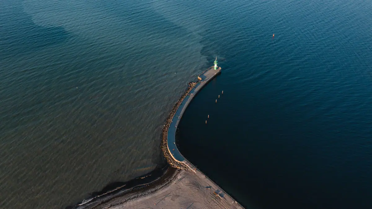 A long pier in Travemünde with a lighthouse on it.