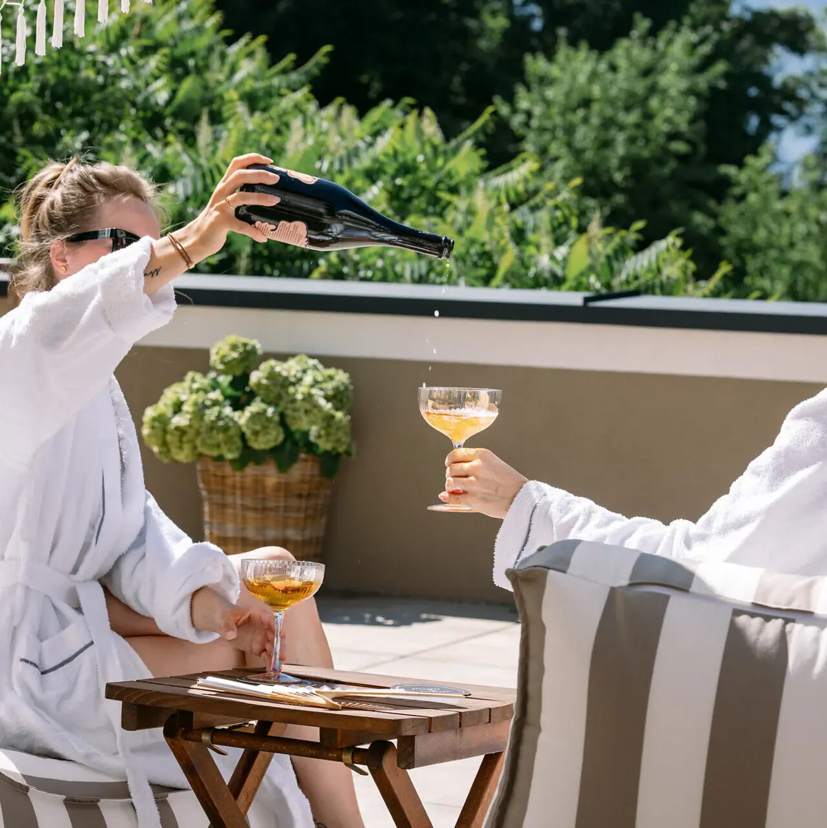 A woman pours wine into a glass.