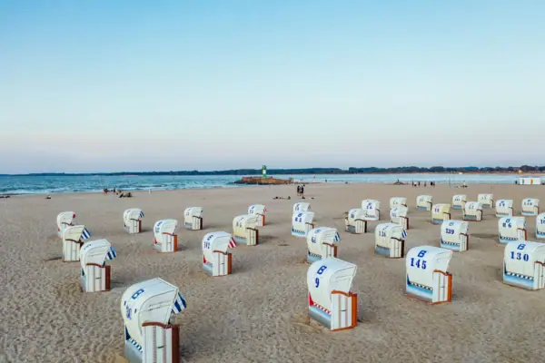 A group of white and blue beach chairs on the beach in Travemünde.