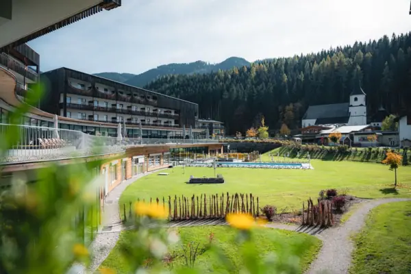 Green lawn with the aja Bergresort Werfenweng in the background.