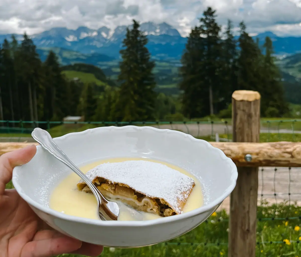 One hand holds a bowl of food and a spoon.