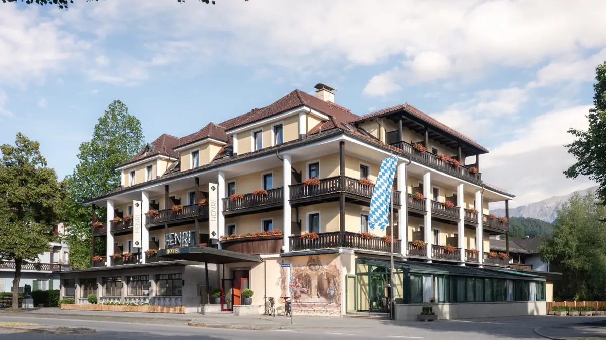 HENRI Garmisch-Partenkirchen A building with many balconies against a cloudy sky.