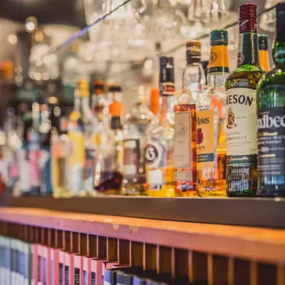 A shelf with bottles of alcoholic drinks.
