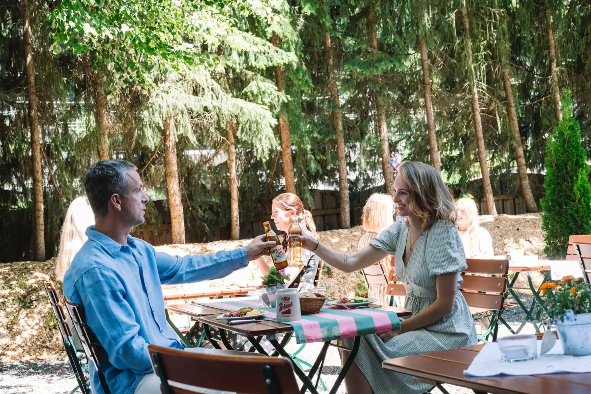 A man and a woman are sitting at a table with drinks.