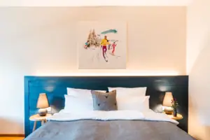 A bed with a painting above it.